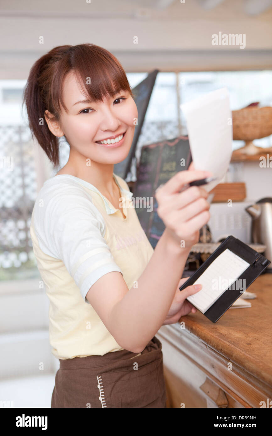 Junge Frau, die arbeitet im café Stockfoto