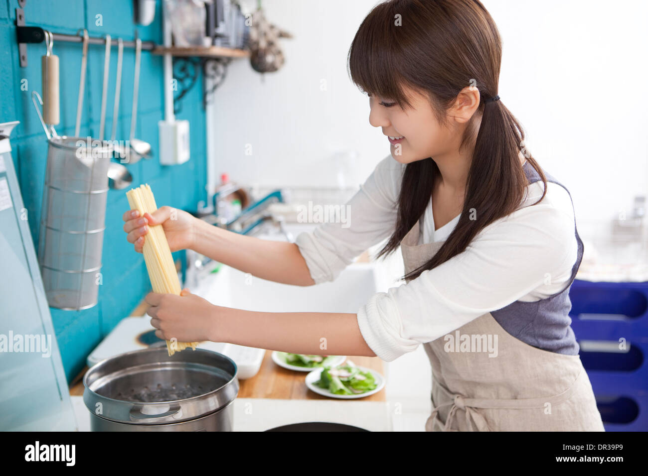 Junge Frau, die Kochen von Teigwaren Stockfoto