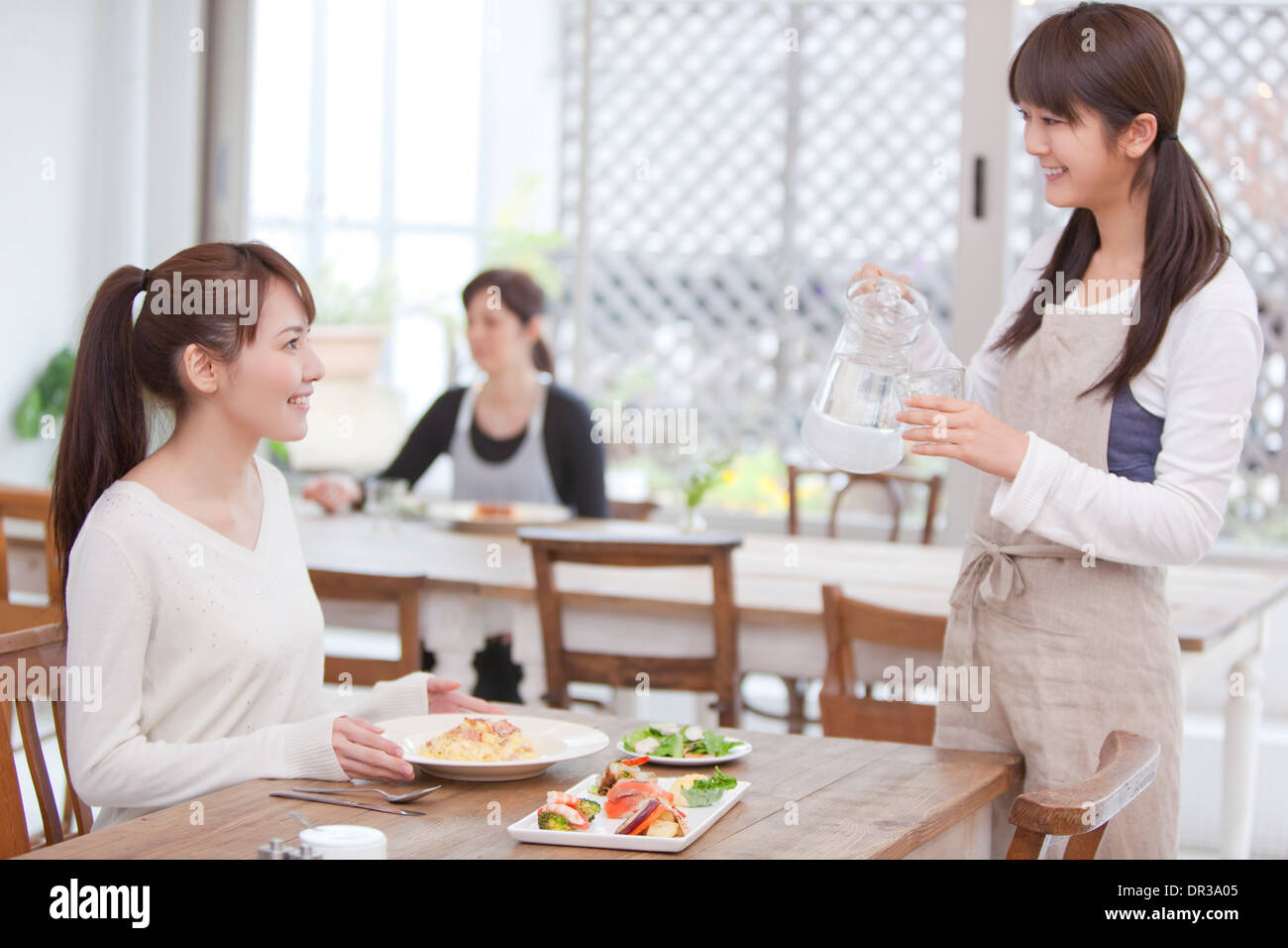 Kellnerin serviert Kunden im café Stockfoto