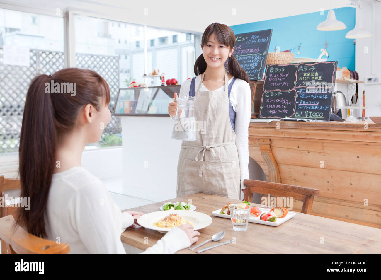 Kellnerin serviert Kunden im café Stockfoto
