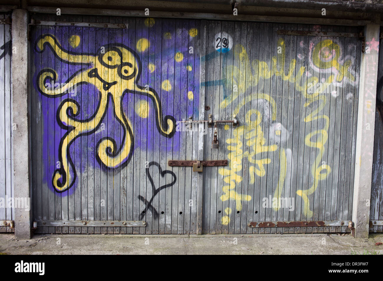 Oktopus wie gelbe alien Graffiti auf einer alten Garage Holztür in Warschau, Polen. Stockfoto
