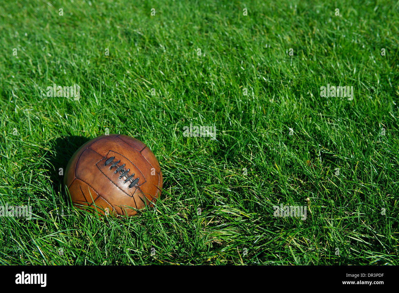 Vintage alte braune altmodischen Fußball Fußball sitzt im sonnigen grünen Wiese Stockfoto