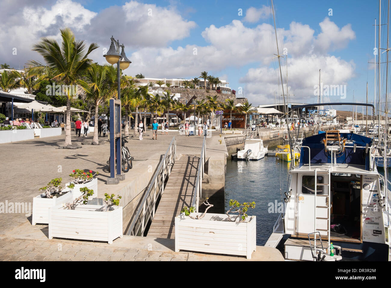 Strandpromenade rund um den Yachthafen im küstennahen Ferienort Puerto Calero, Lanzarote, Kanarische Inseln, Spanien Stockfoto