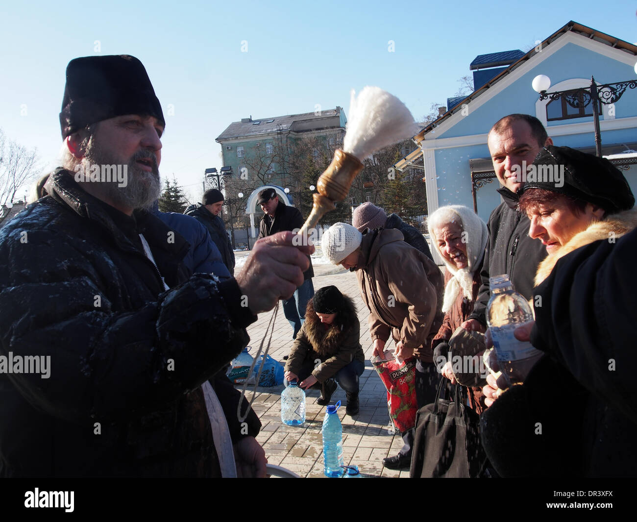 Ukraine, Lugansk - Januar 19. 2013: der Priester besprengt Weihwasser auf die Gläubigen.  Epiphanie - eines der ältesten Feste der Christian Church. Seine Gründung geht zurück zu den Tagen der Apostel. Dieser Feiertag schließt ein strenges Fasten und Orthodoxe Gläubigen wirklich lieben. Bildnachweis: Igor Golovnov/Alamy Live-Nachrichten Stockfoto