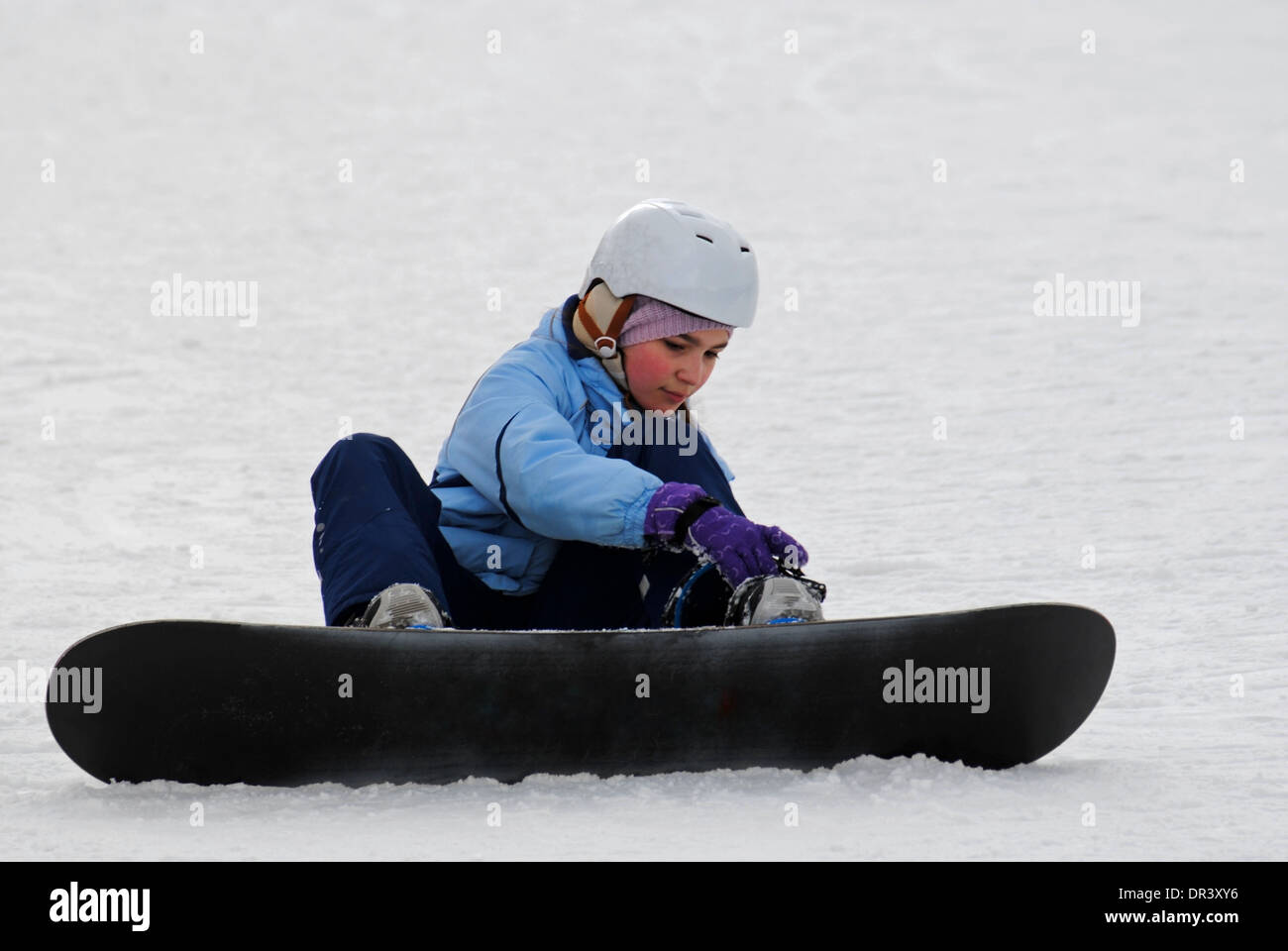 Kleines Mädchen, die Vorbereitung für den Abstieg des Berges auf einem Snowboard. Stockfoto