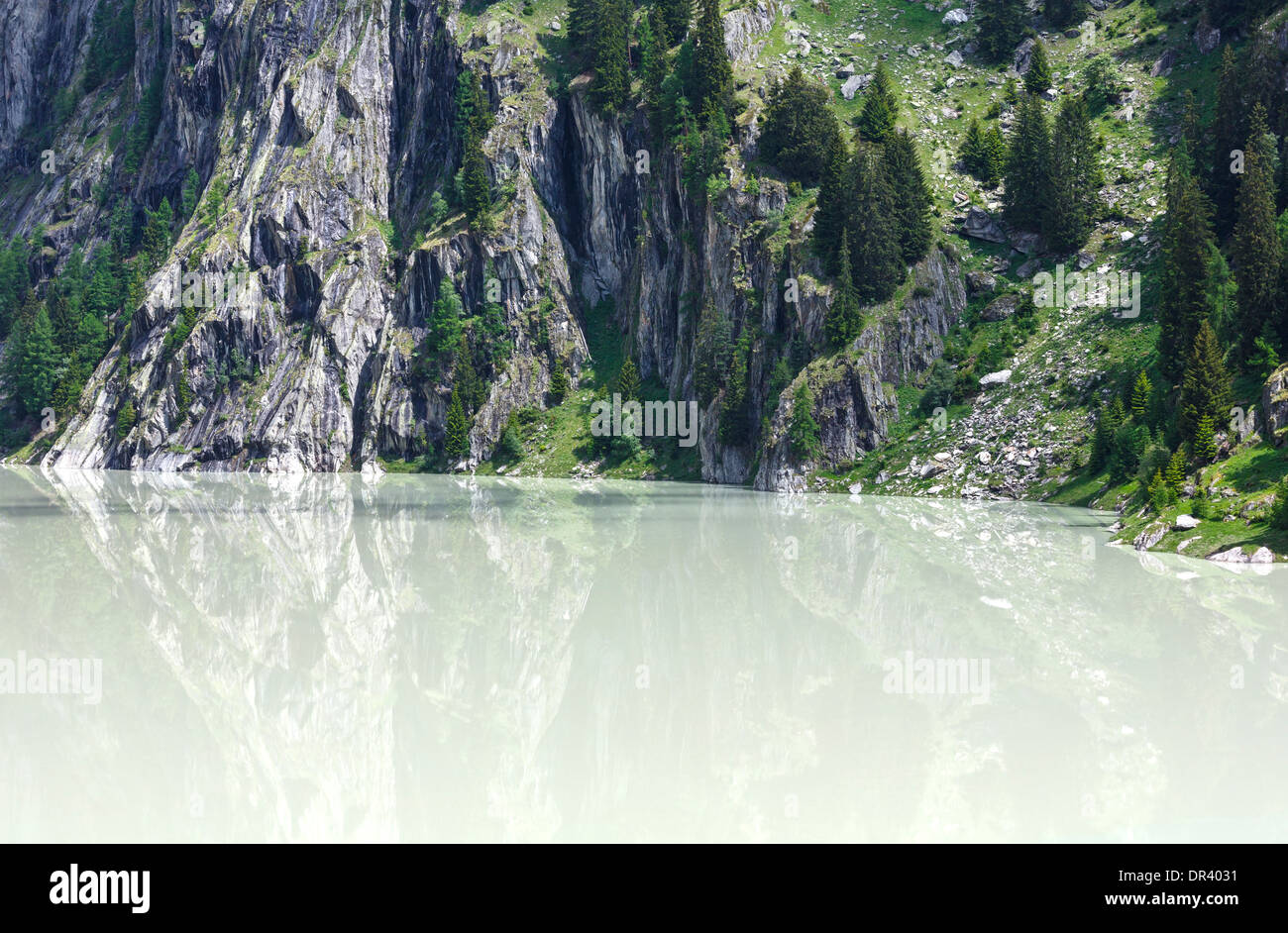 See mit trübem Wasser gebildet, den Damm. Sommer-Berglandschaft (Alpen, Schweiz) Stockfoto