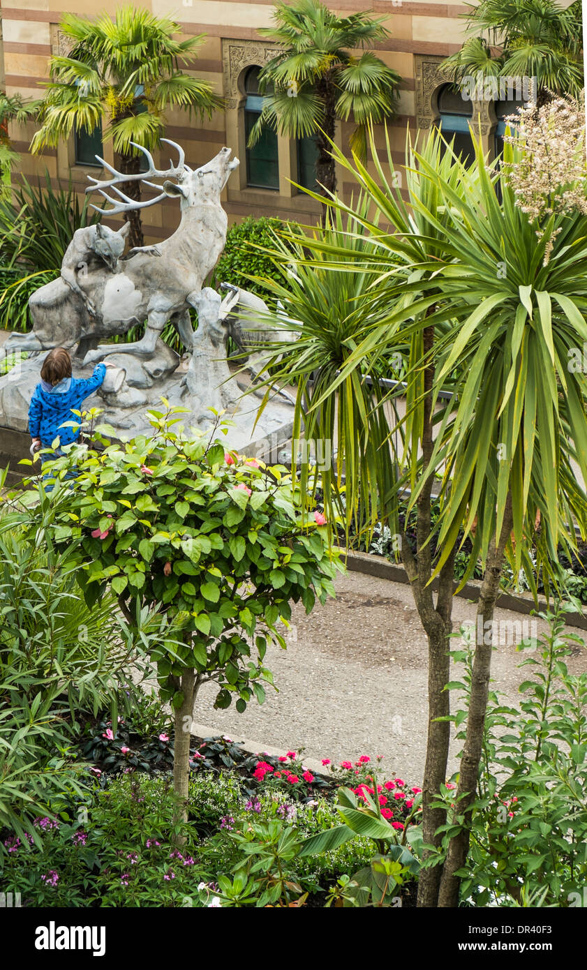 Skulptur von Hunden Angriff auf ein lieber im Hintergrund, Fassade im maurischen Stil in den Zoologisch-Botanischen Garten  wil Stockfoto