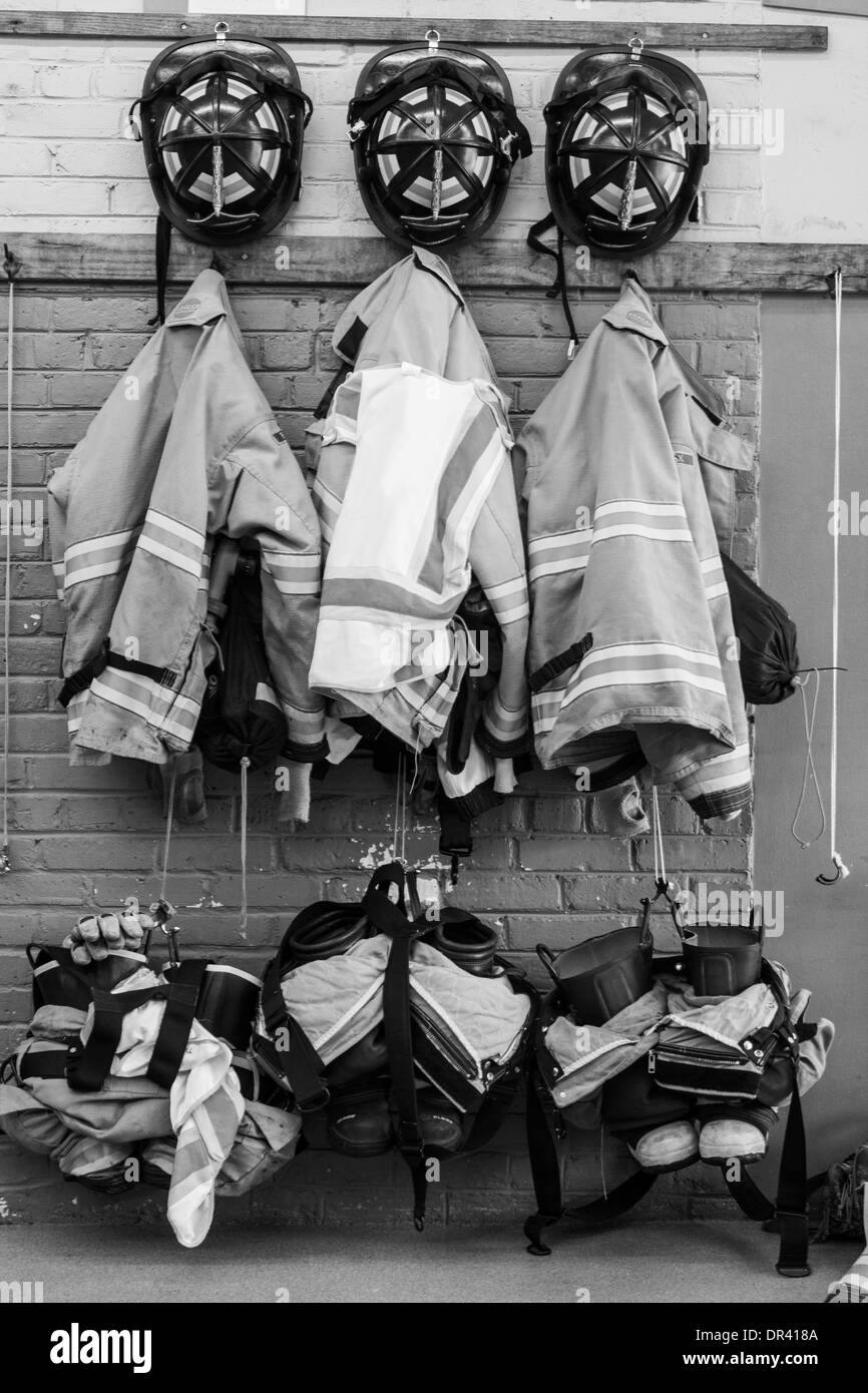 Drei Feuerwehr-Uniformen hängen an der Station Wand HDR Stockfoto