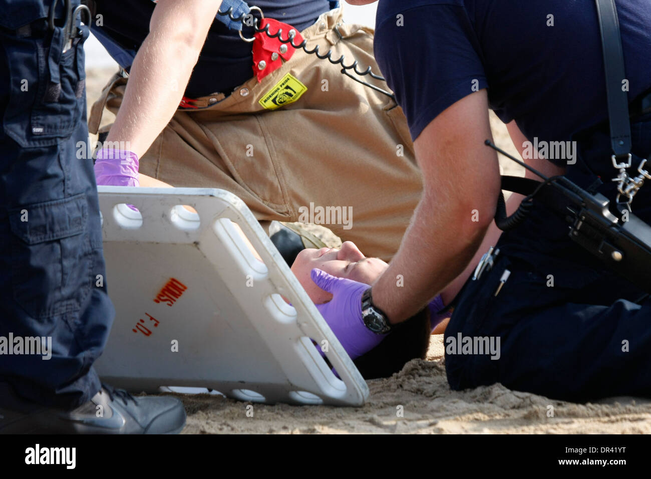 Sanitäter bei der Szene eines mass Casualty Vorfalls helfen Opfer auf eine Rückwand Stockfoto