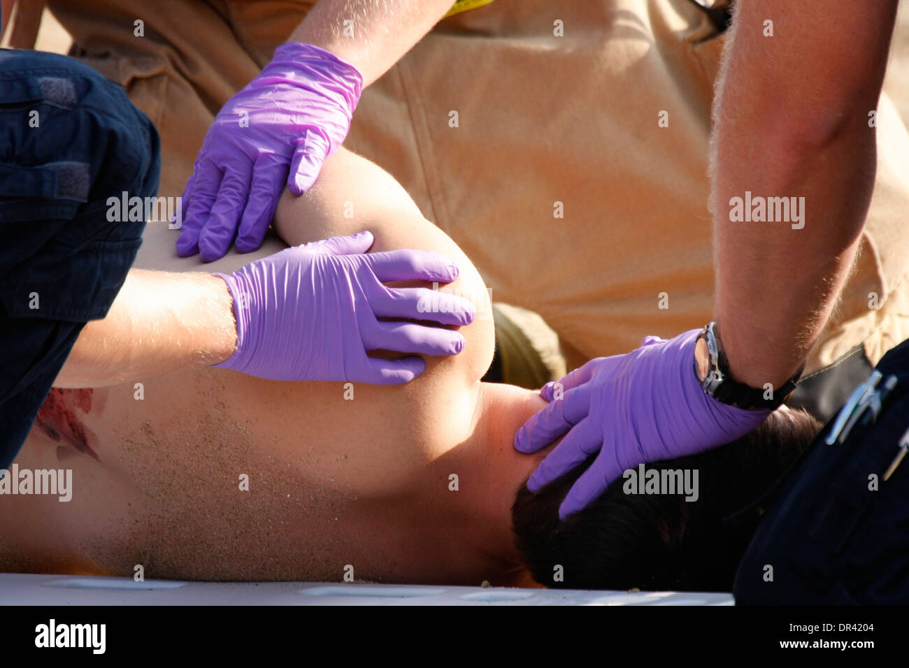 Sanitäter bei der Szene von einem mass Casualty Übung hilft ein Opfer auf eine Rückwand Stockfoto