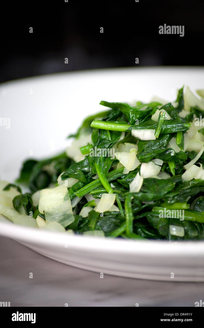 Gekochtem oder gedünstetem Spinat auf einem weißen Teller Stockfoto