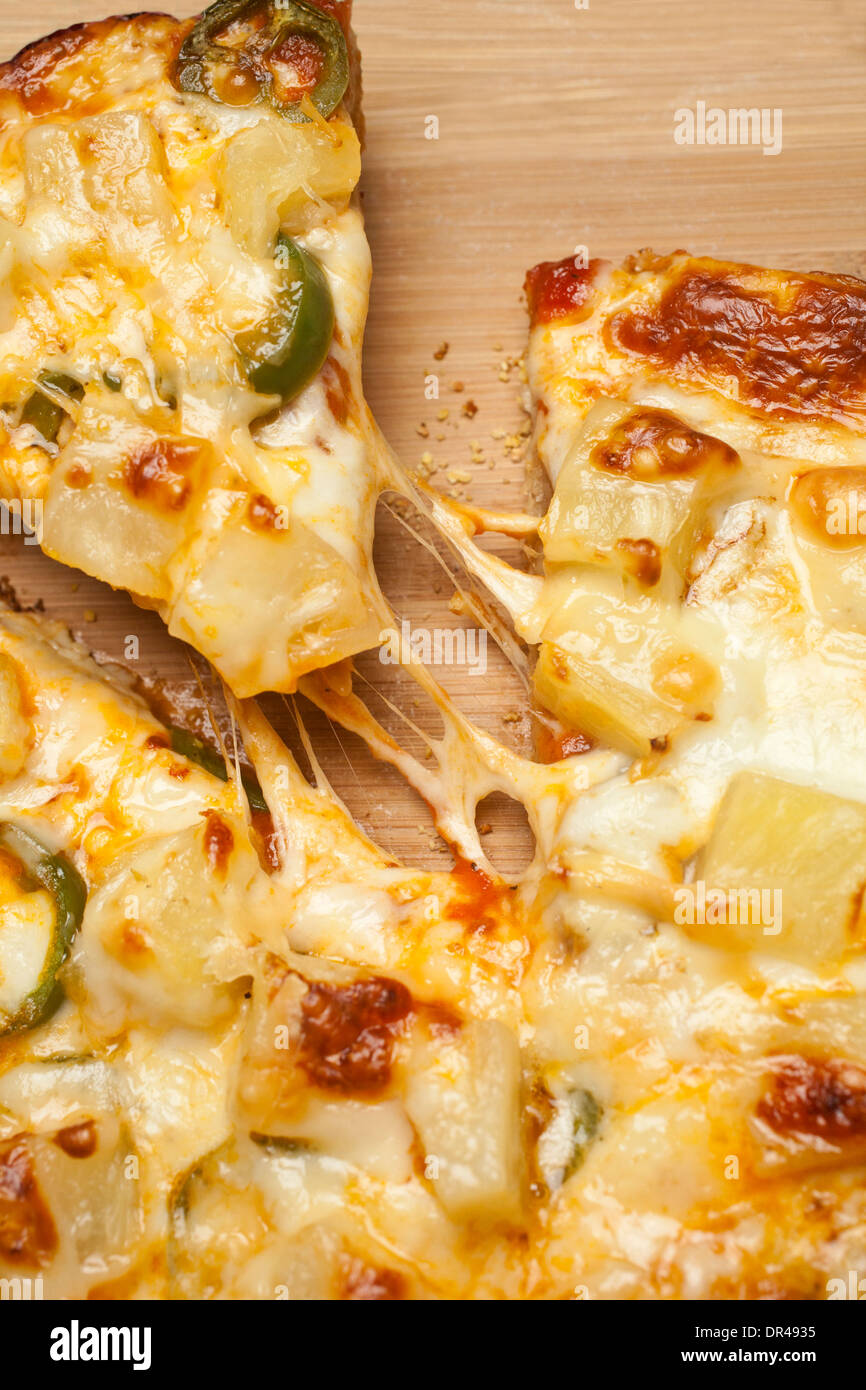 Das erste Stück Käse Pizza greifen Stockfoto
