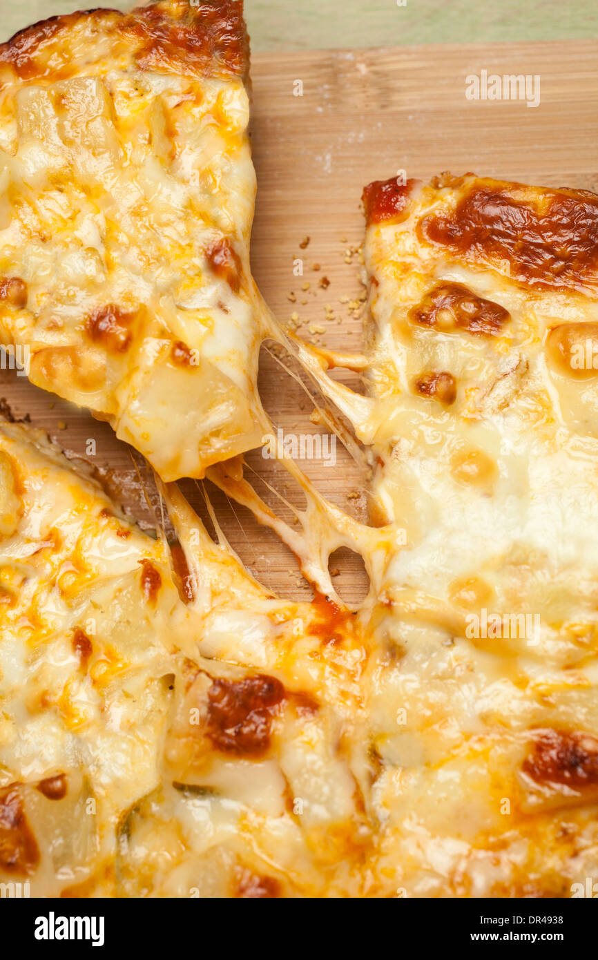 Das erste Stück Käse Pizza greifen Stockfoto