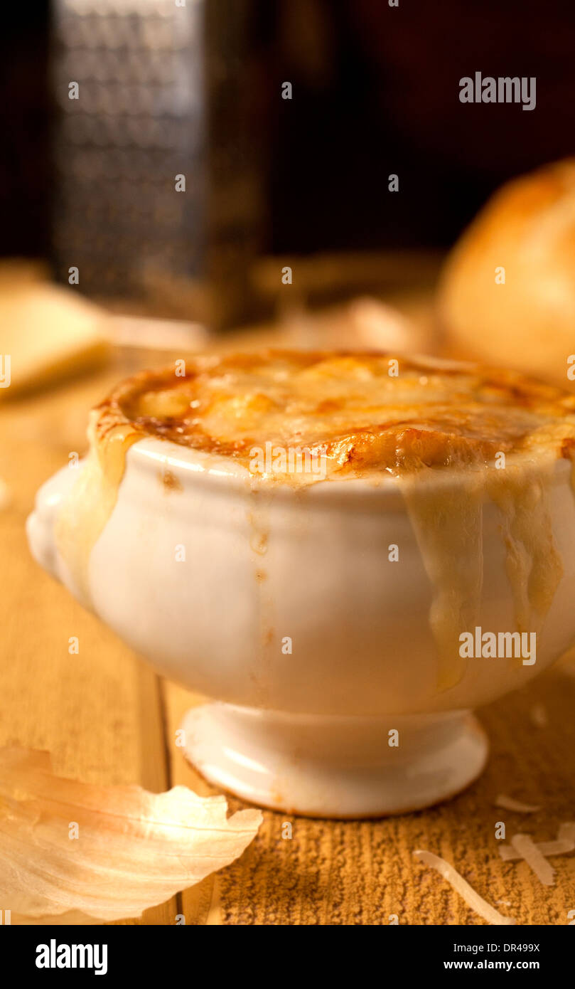 Französische Zwiebelsuppe mit geriebenem Käse und ein rundes Laib Brot Stockfoto