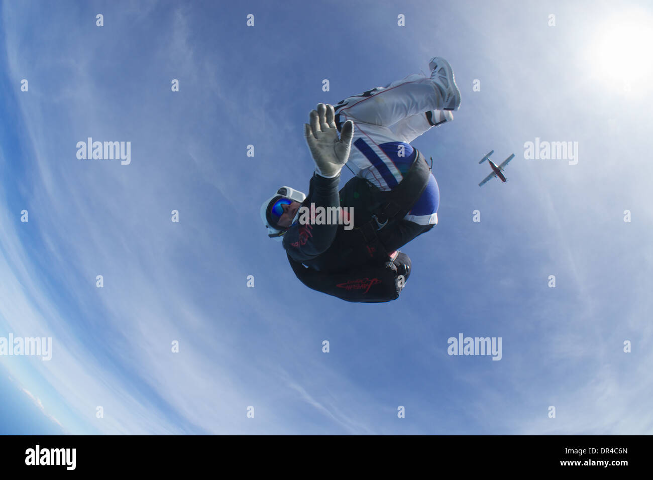 Fallschirmspringer im freien Fall über Diani Beach, Kenia. das Flugzeug, das er von im Hintergrund beendet wird. Stockfoto