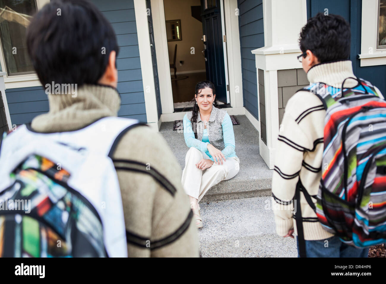 Hispanische Mutter Gruß Söhne an Tür Stockfoto