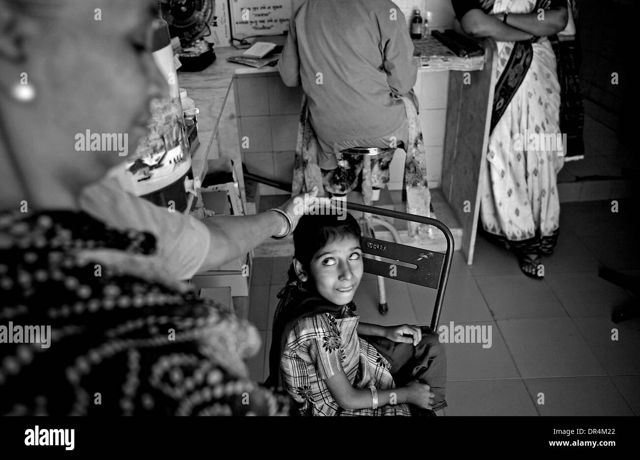24. Januar 2009 - Zentrum DOTS Centre, Ahmedabad, Gujarat, Indien - Hauch von Sorge und ein stilles Gebet, nun wird liebevoll getröstet durch ihre Großmutter Sangitaben auf die Punkte in Ahmedabad. Extra Lungentuberkulose hat Munnis Rückenmarks betroffen, und das betrifft die physische Kontrolle und Bewegung der Augen sowie. Sie findet es schwer zu stehen und zu gehen. Nach T geheilt haben Stockfoto