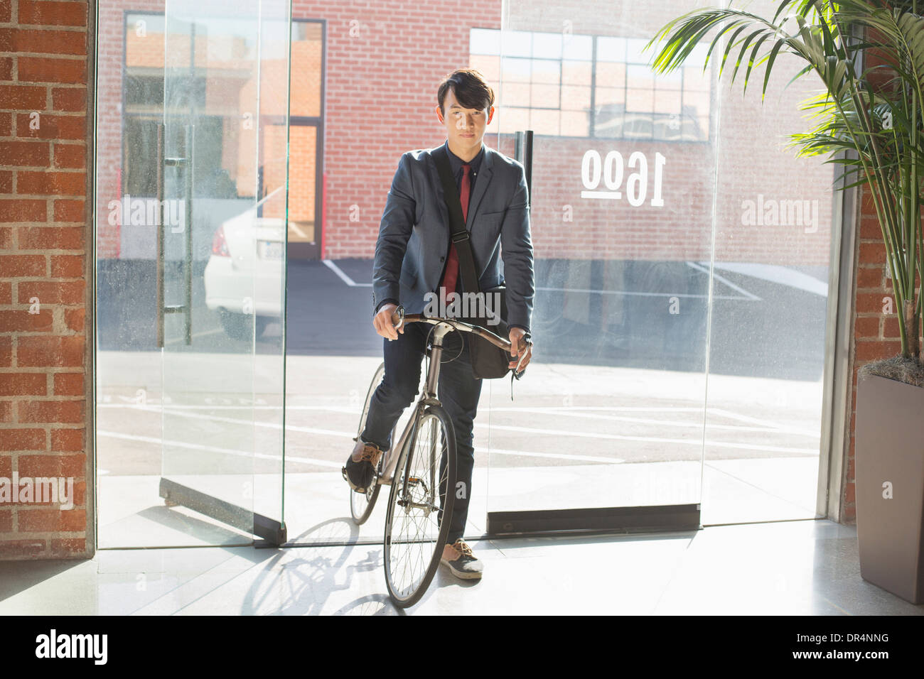 Koreanischer Geschäftsmann Machenschaften Fahrrad im Büro Stockfoto