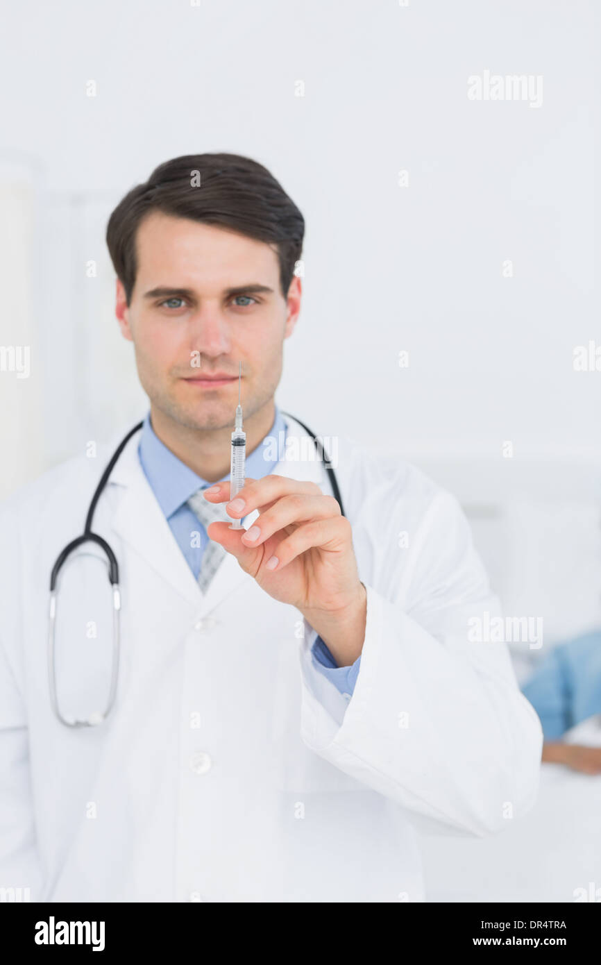 Gut aussehend männlichen Arzt hält eine Injektion Stockfoto