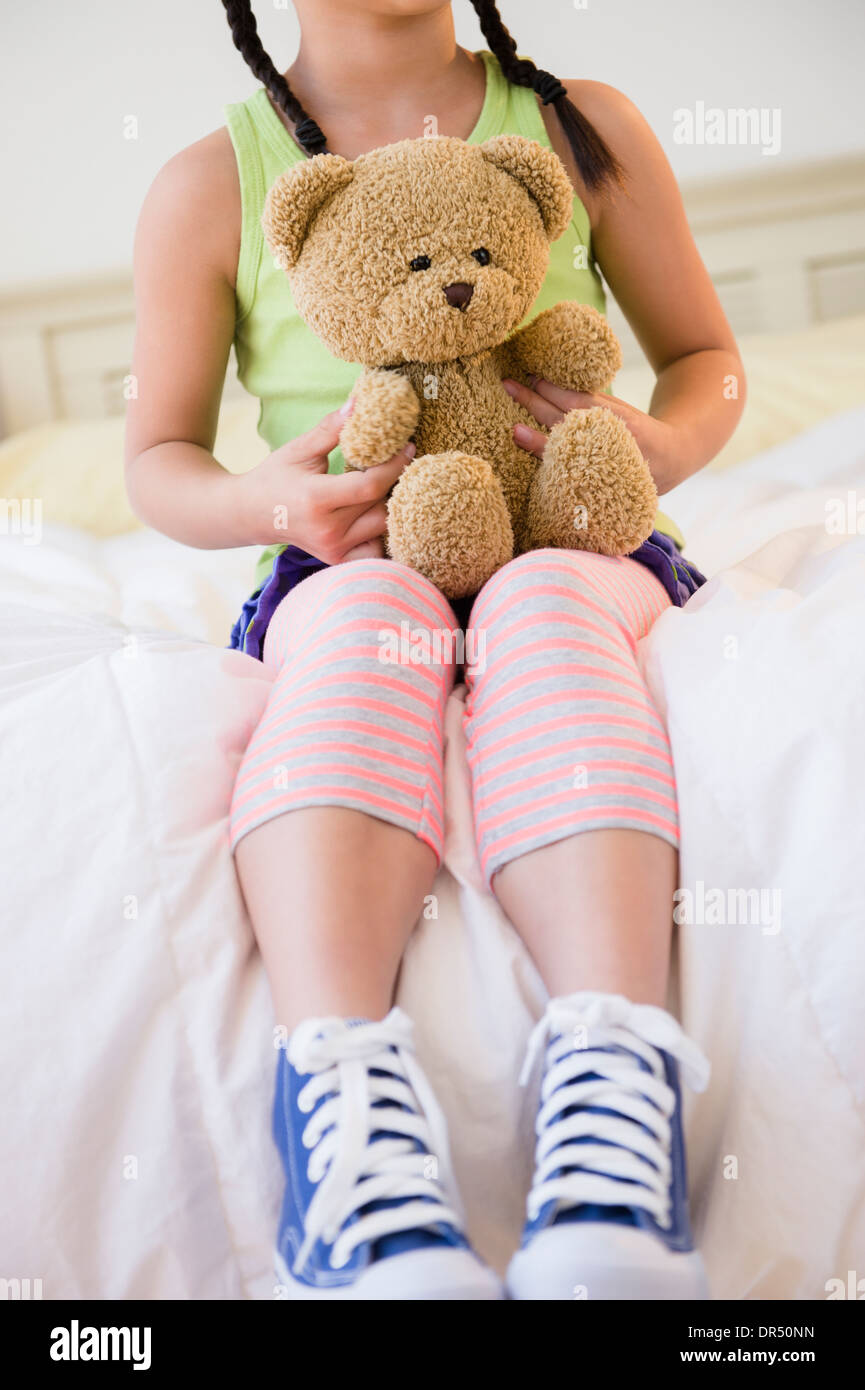 Koreanisches Mädchen mit Teddybär auf Bett Stockfotografie - Alamy