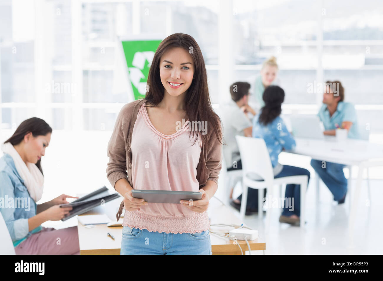 Künstler mit digital-Tablette mit Kollegen im Hintergrund im Büro Stockfoto