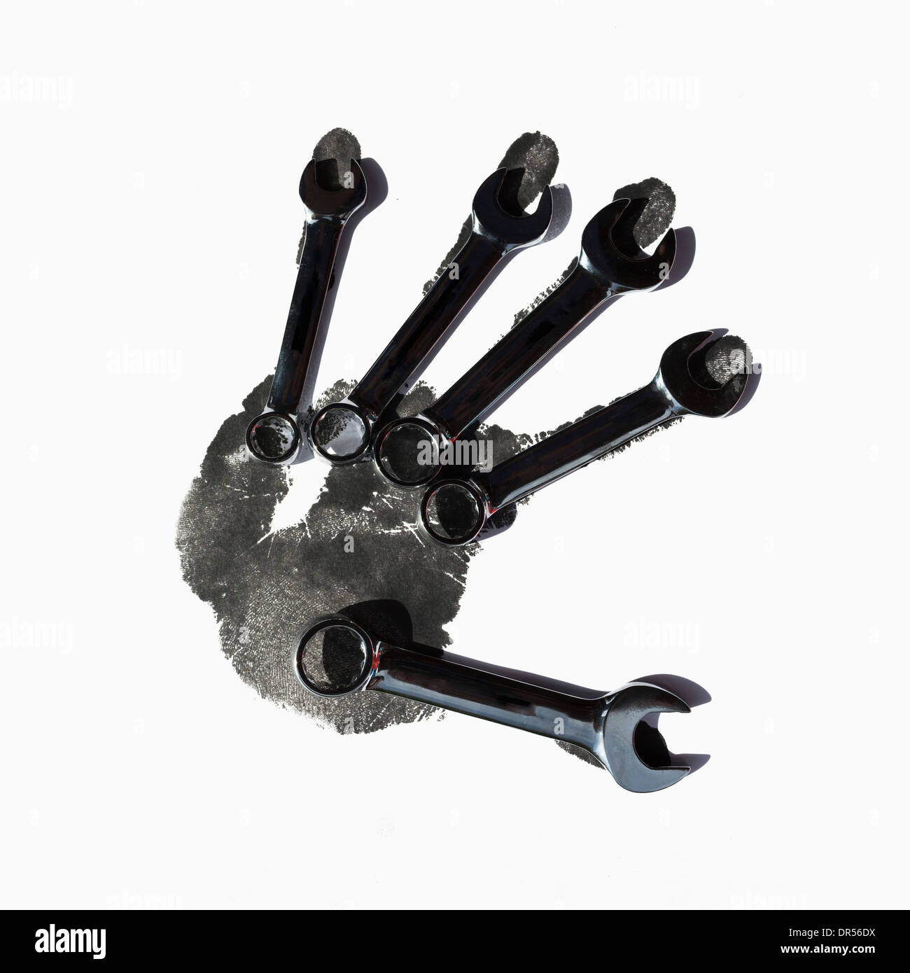 Schraubenschlüssel über schwarzer Handabdruck Stockfoto