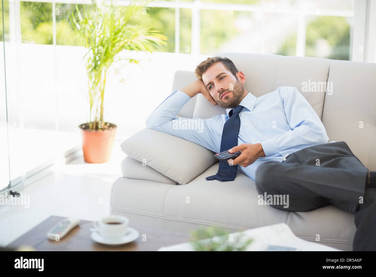 Gut gekleideter Mann vor dem Fernseher im Wohnzimmer Stockfoto