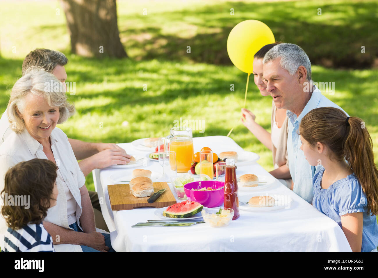 Großfamilie, die Speisen am Tisch im freien Stockfoto