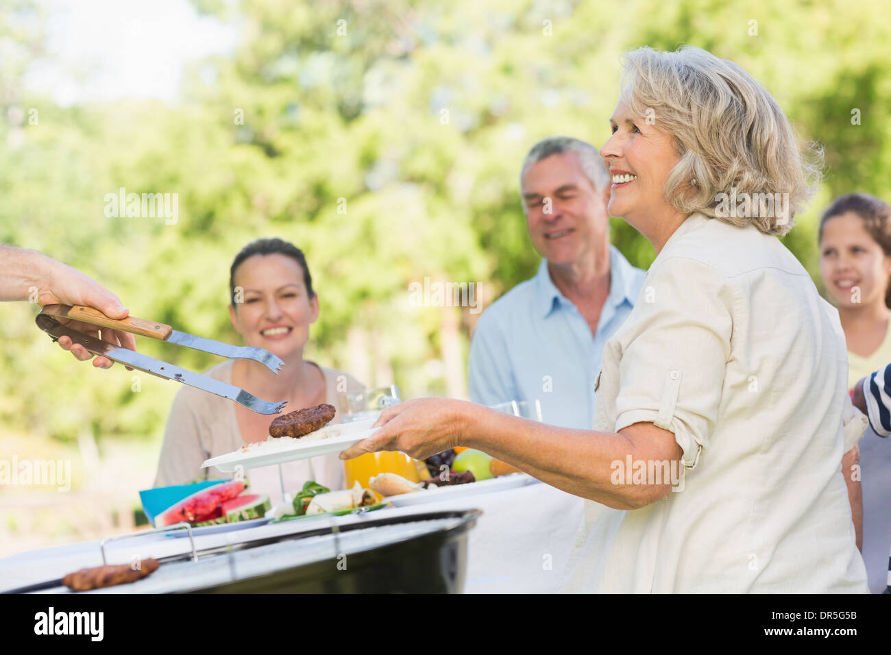 Großfamilie, die Speisen am Tisch im freien Stockfoto