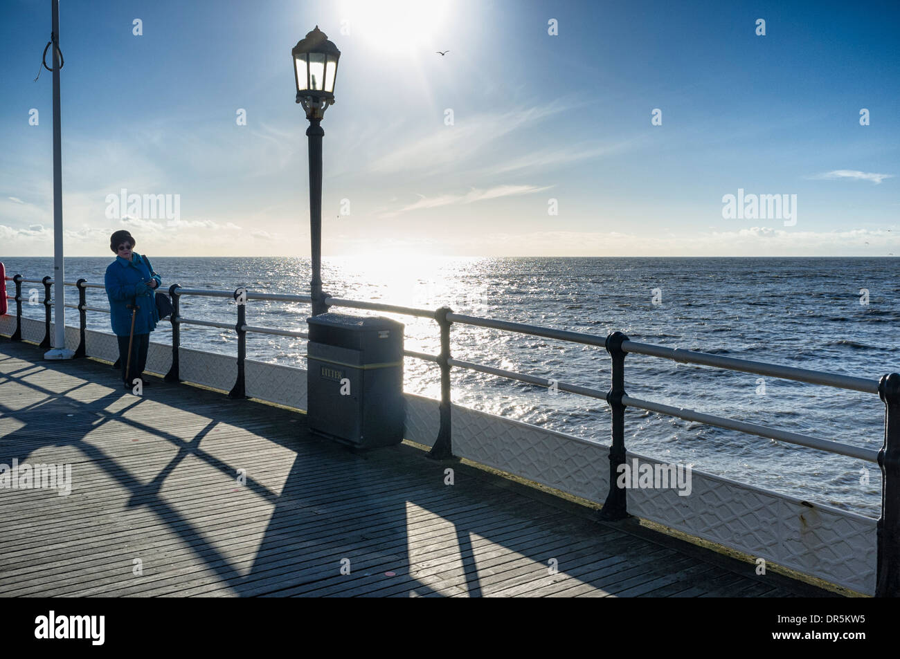 Eine Frau steht im Schatten Wintersonne.  Worthing. Bild von Julie Edwards Stockfoto