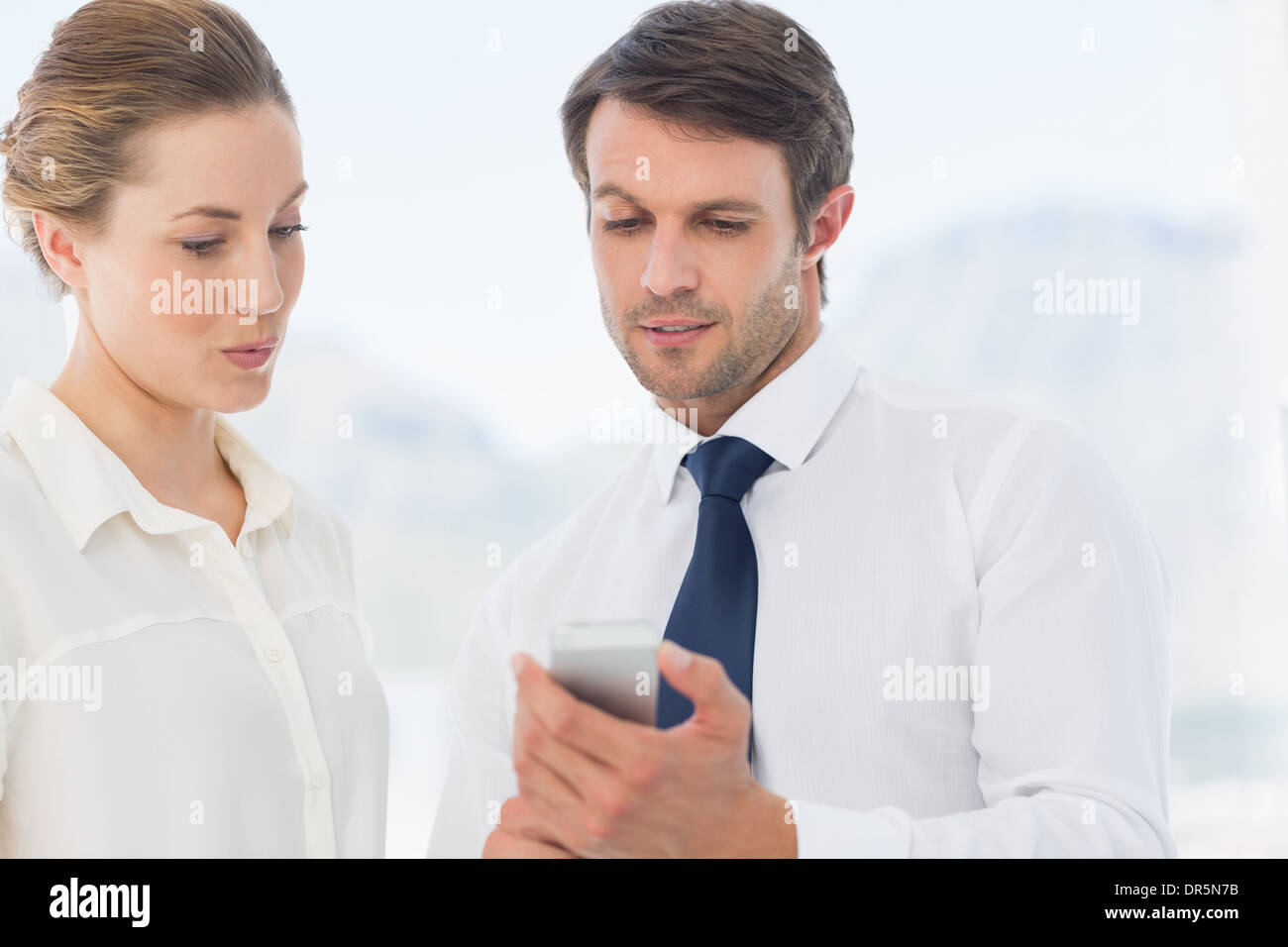 Elegant gekleidet Kollegen Blick auf Handy Stockfoto