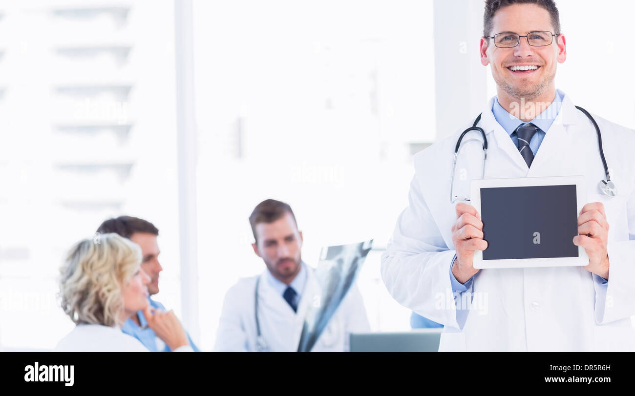 Arzt hält digitale Tablet mit Kollegen treffen Stockfoto
