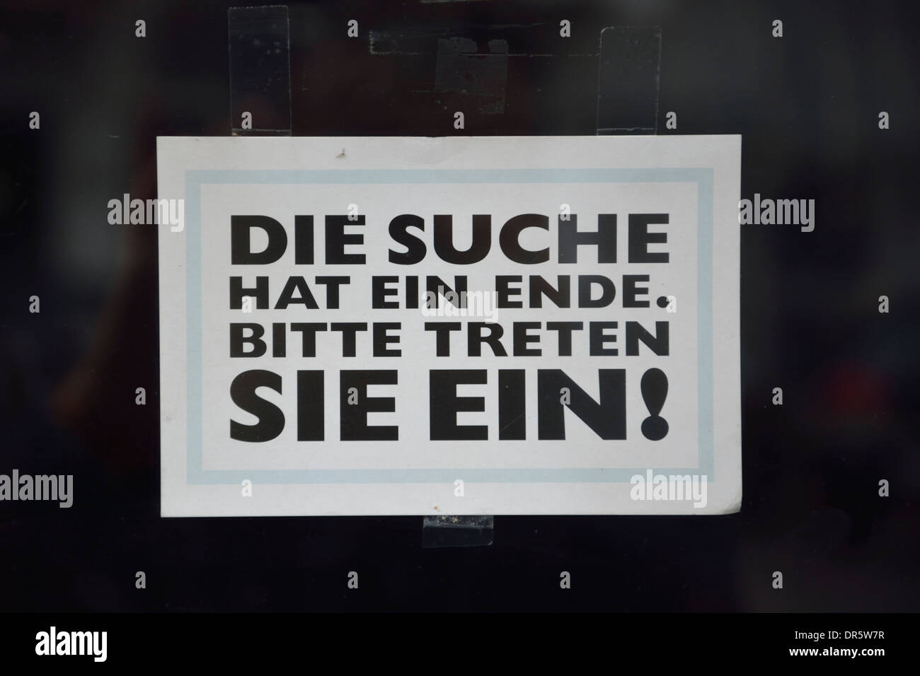 Blatt Papier mit einladenden am schwarzen Tor treten Stockfoto