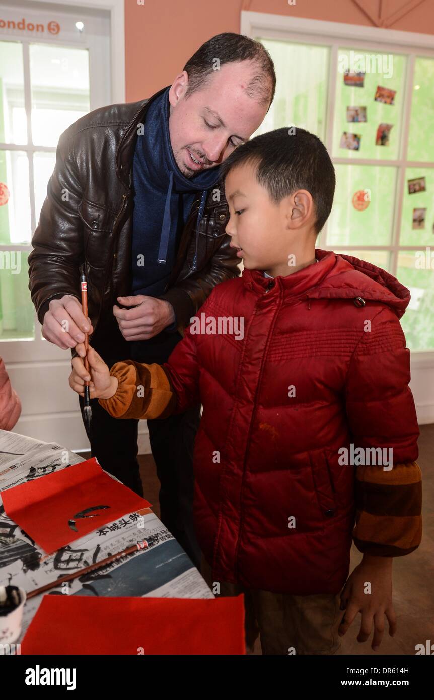 Hangzhou, China Zhejiang Provinz. 20. Januar 2014. Kevin (L), ein ausländischer Lehrer aus den USA lernt schreiben Kalligraphie von Qian Qiaoyue, einem jungen der vierten Klasse in einer Gemeinde in Hangzhou, Hauptstadt der ostchinesischen Provinz Zhejiang, 20. Januar 2014. Insgesamt 50 einige Kinder und ihr ausländische Lehrer Kevin feierte das kommende Frühlingsfestival durch verschiedene volkstümliche Aktivitäten am Montag. © Xu Yu/Xinhua/Alamy Live-Nachrichten Stockfoto