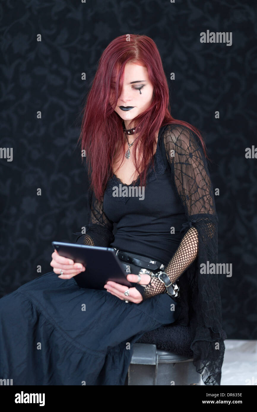 Junge Frau trägt Mode der Gotik mit Tablet-PC Stockfoto
