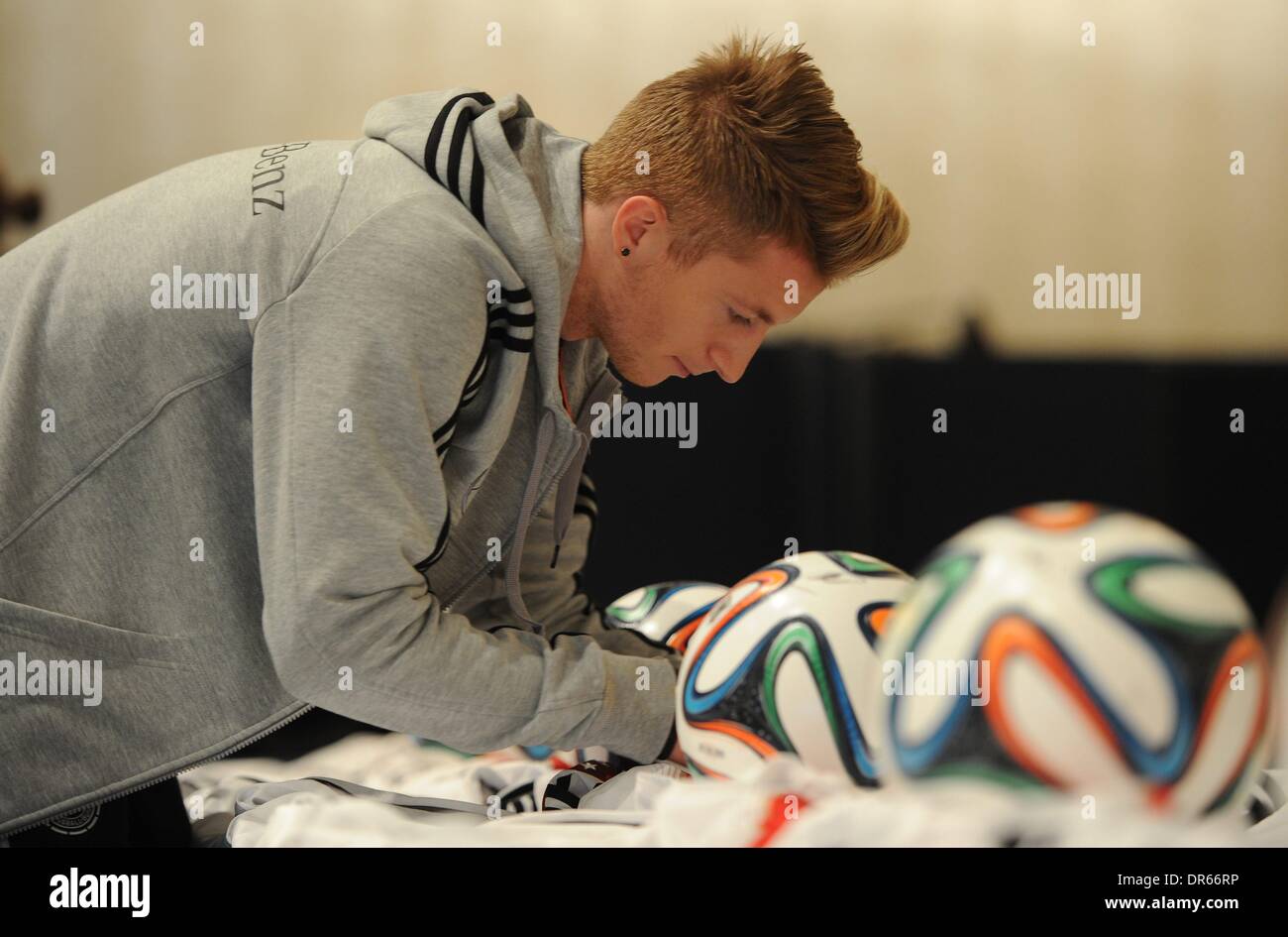 München, Deutschland. 20. Januar 2014. Deutsch National Football Team Marketing Day in München, Marco REUS unterschreibt Kugeln mit seiner Unterschrift Credit: Norbert Schmidt/Alamy Live News Stockfoto