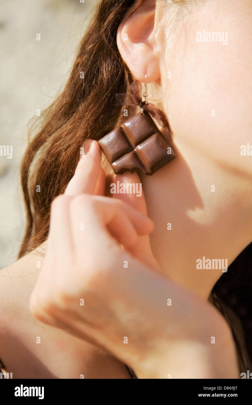 Ohrring in Form von Schokolade im Ohr Stockfoto