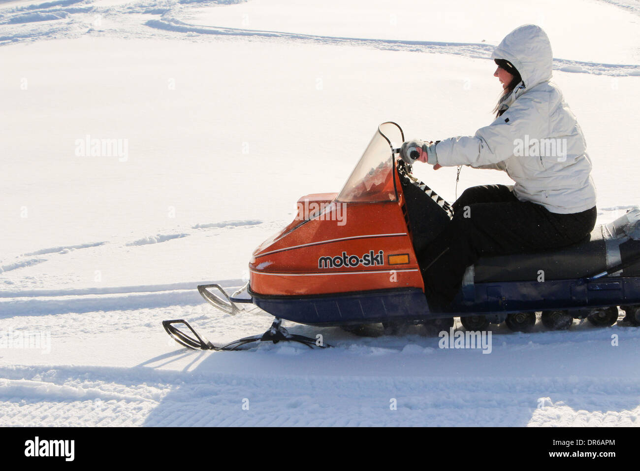 Eine Frau in ihren frühen 30ern genießen ein Schneemobil fahren nach Neuschnee in Quebec, Kanada. Stockfoto