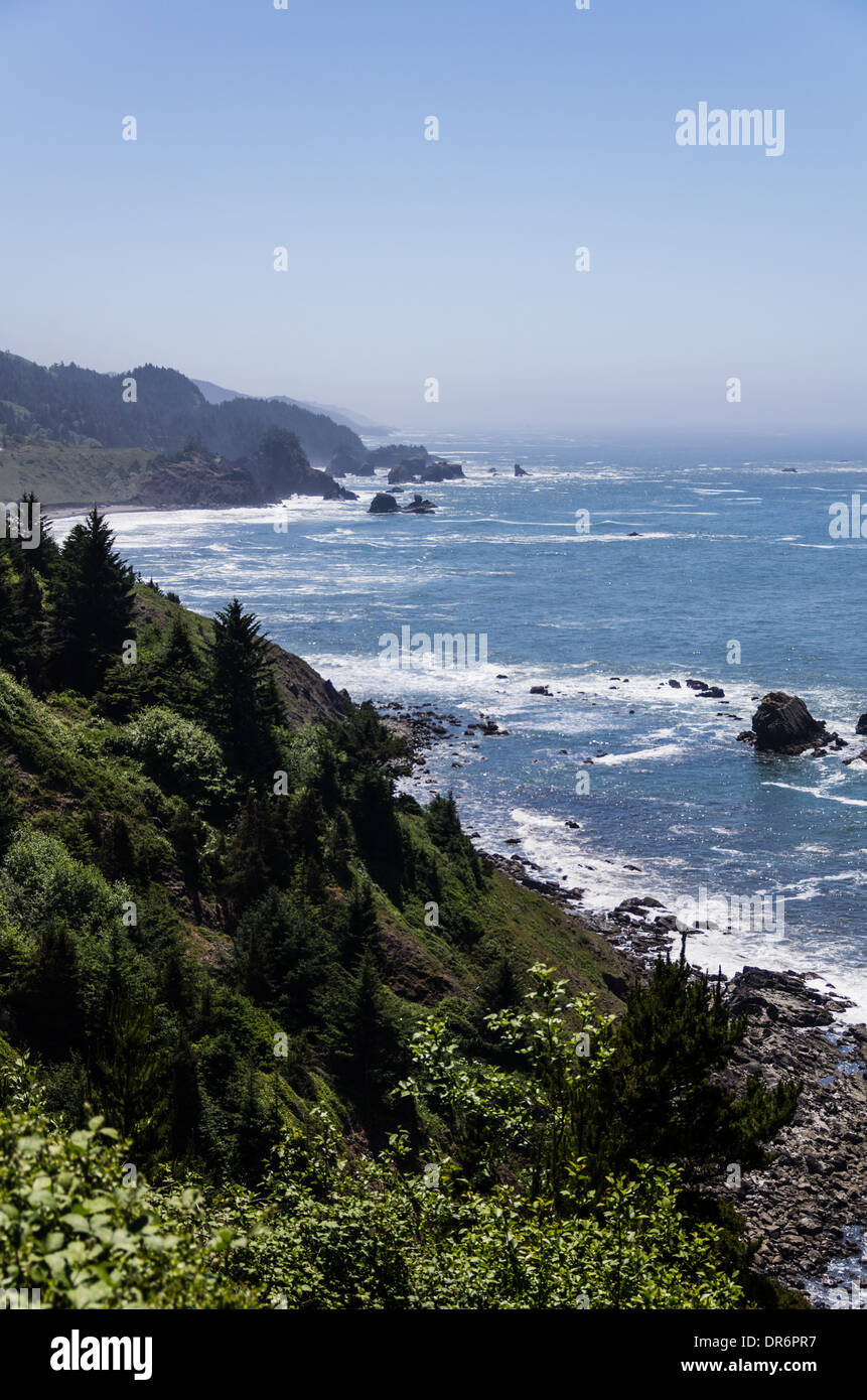 Blick auf die Küste von Oregon mit Wellen an Land kommen an einem steinigen Strand.  Brookings, Oregon Stockfoto