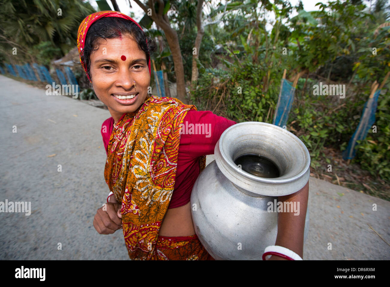 Eine Dorf Frau sammelt Wasser in einem abgelegenen Subsistenzwirtschaft Dorf auf einer Insel in der Sunderbans, das Ganges Dreieck im Osten Indiens, die sehr anfällig für Meeresspiegelanstieg ist. Stockfoto