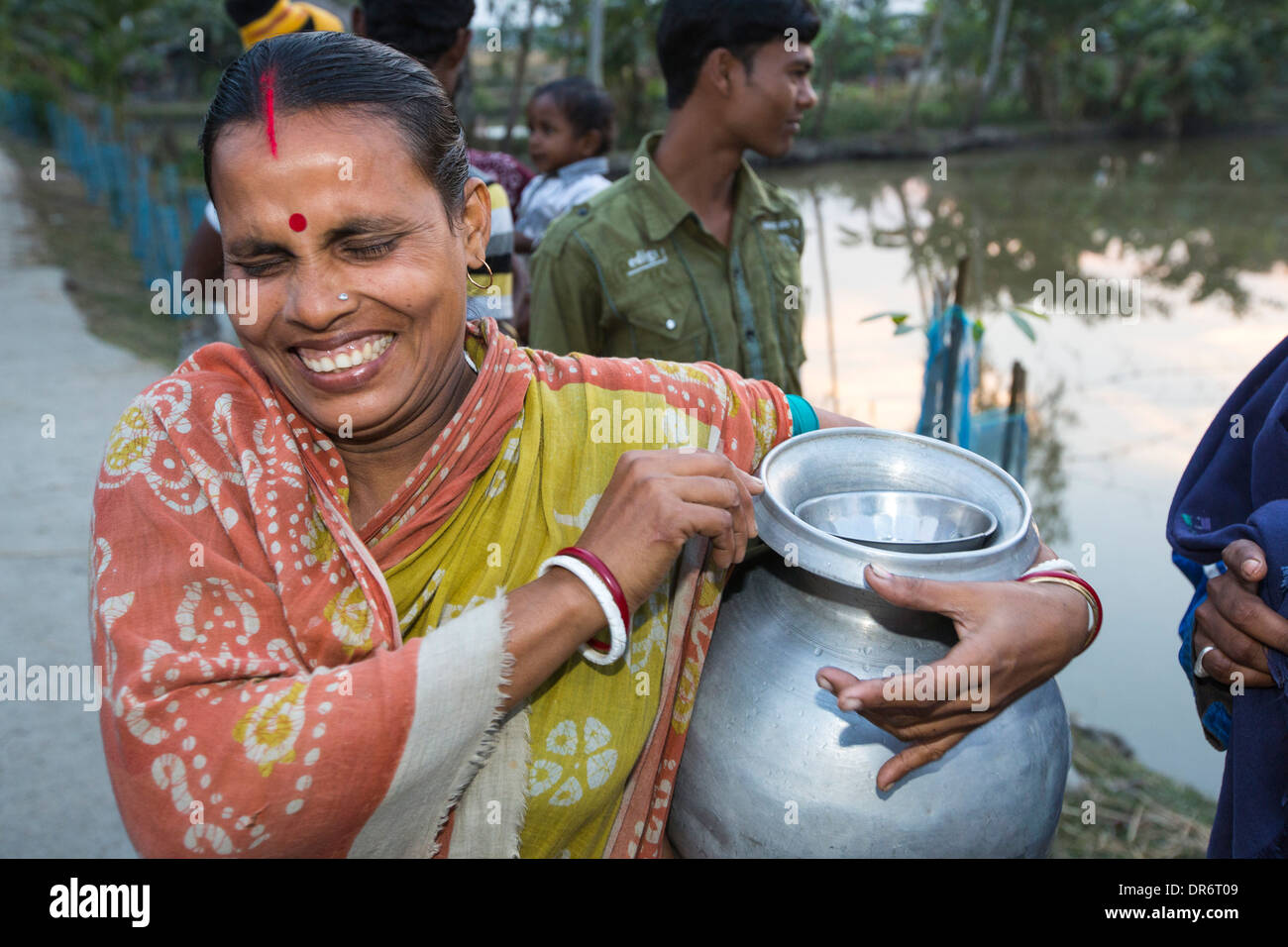 Eine Dorf Frau sammelt Wasser in einem abgelegenen Subsistenzwirtschaft Dorf auf einer Insel in der Sunderbans, das Ganges Dreieck im Osten Indiens, die sehr anfällig für Meeresspiegelanstieg ist. Stockfoto