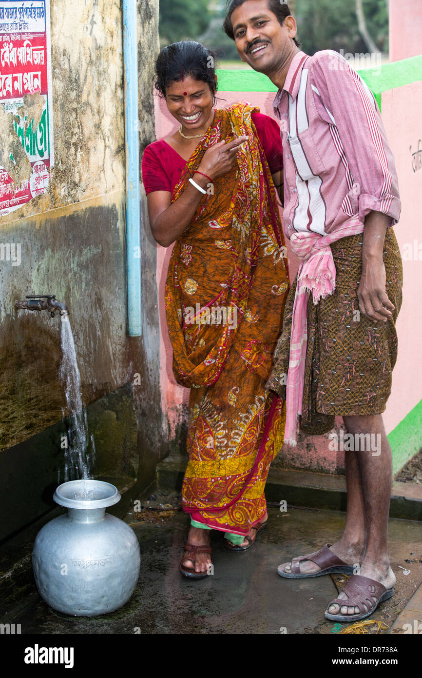 Dorfbewohner auf einer abgelegenen Insel in der Sunderbans, einen tief liegenden Bereich, anfällig für Meeresspiegelanstieg, Indien, sammeln auch Wasser aus dem Bohrloch. Stockfoto
