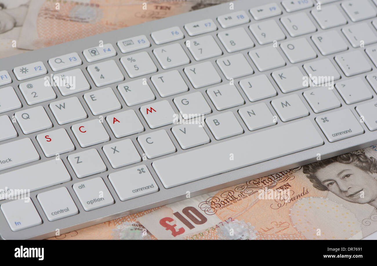 Computer-Tastatur mit Buchstaben des Arbeit Betrugs auf einem Haufen von zehn Pfund-Noten Stockfoto