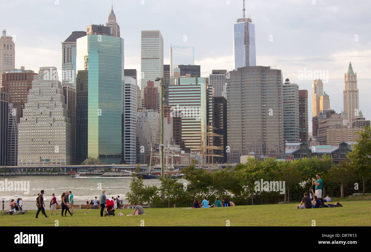 Menschen im Brooklyn Bridge Park vor der Kulisse der Skyline der Innenstadt Manhattan an einem Herbsttag im September 2013. Stockfoto