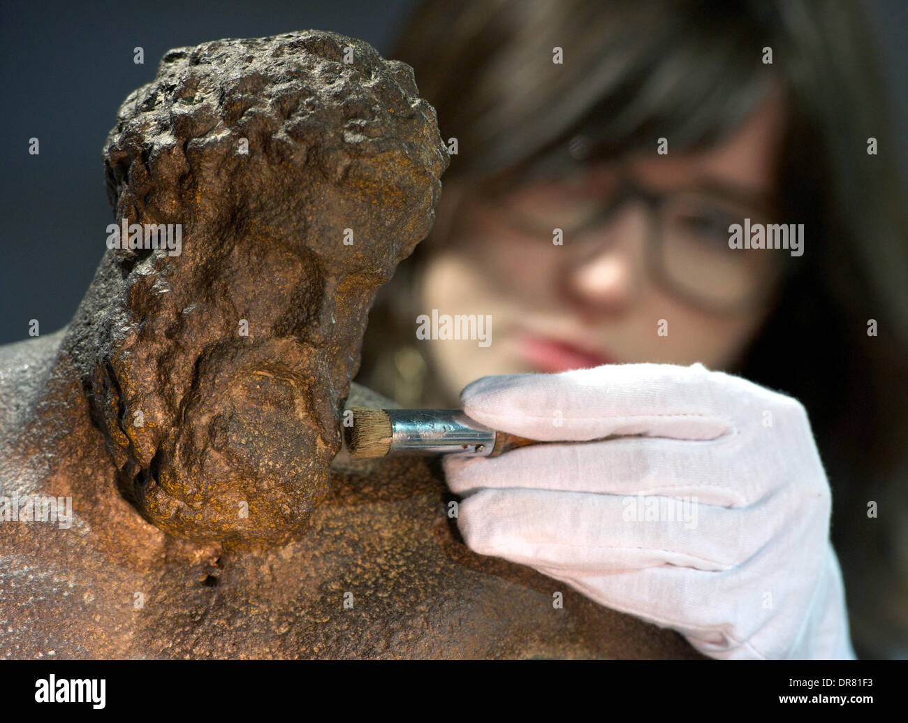 US amerikanische Intern Westrey Page reinigt die Eisen-Besetzung der antiken griechischen Figur des Herkules Farnese aus dem 19. Jahrhundert in der Restaurierungswerkstatt des Grassi Museum in Leipzig, Deutschland, 21. Januar 2014. Heute ist das Museum zog eine Bilanz des vergangenen Jahres 2013 und gab eine Vorschau auf die Highlights des Jahres 2014. Foto: Peter Endig/dpa Stockfoto