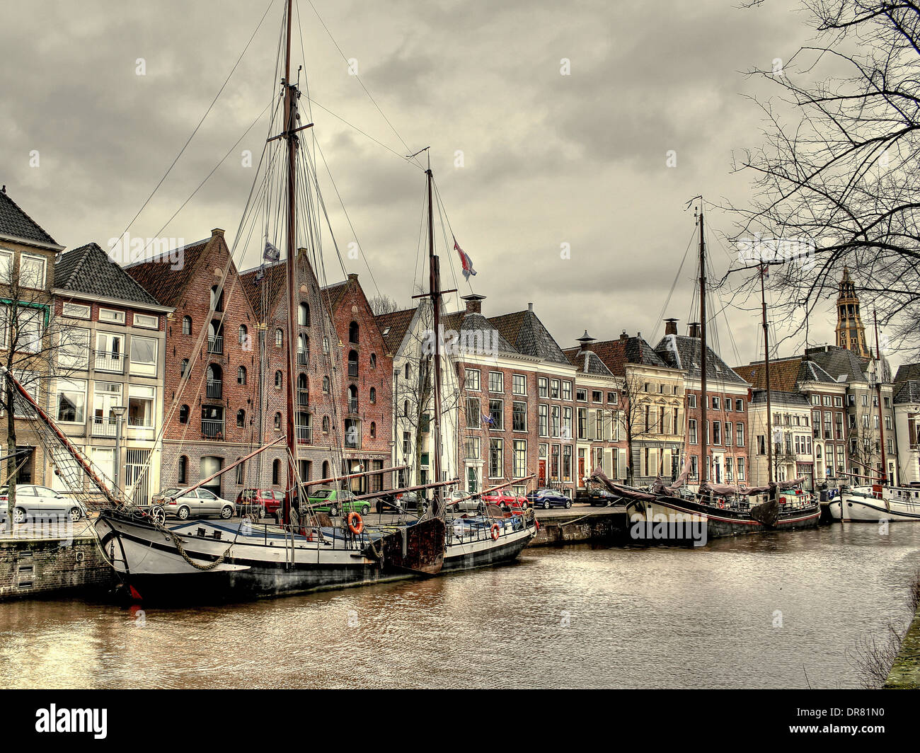 Segelschiffe im Winter in den Kanal bei Hoge der A in Groningen, Niederlande mit Der Aa-Kerk im Hintergrund Stockfoto