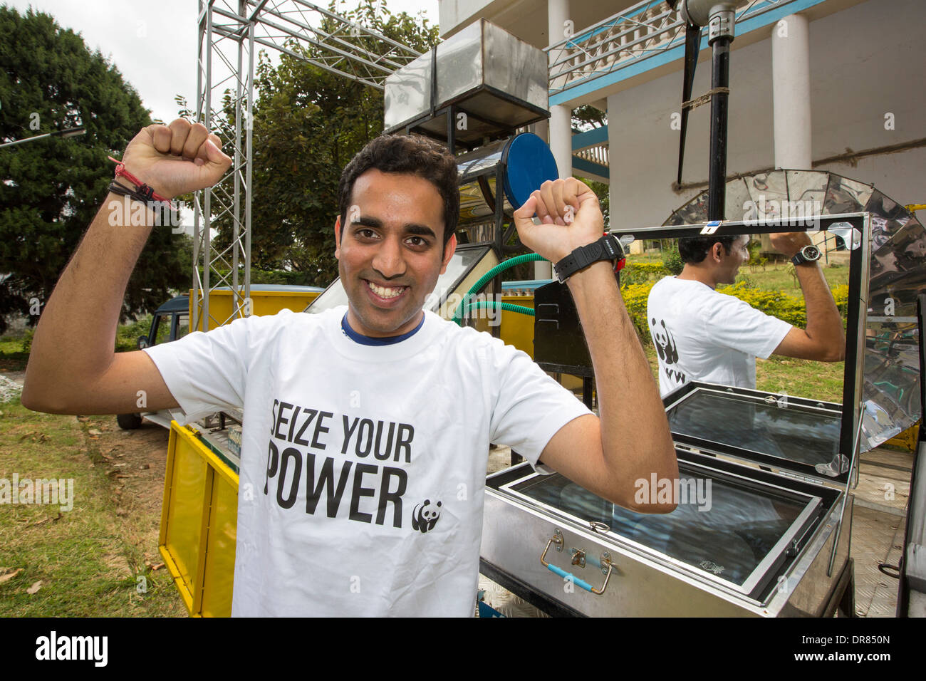 Ein junger Mann trägt einen nutzen Ihre macht Tshirt, eine Kampagne des WWF zur Förderung erneuerbarer Energien, neben einem LKW Stockfoto