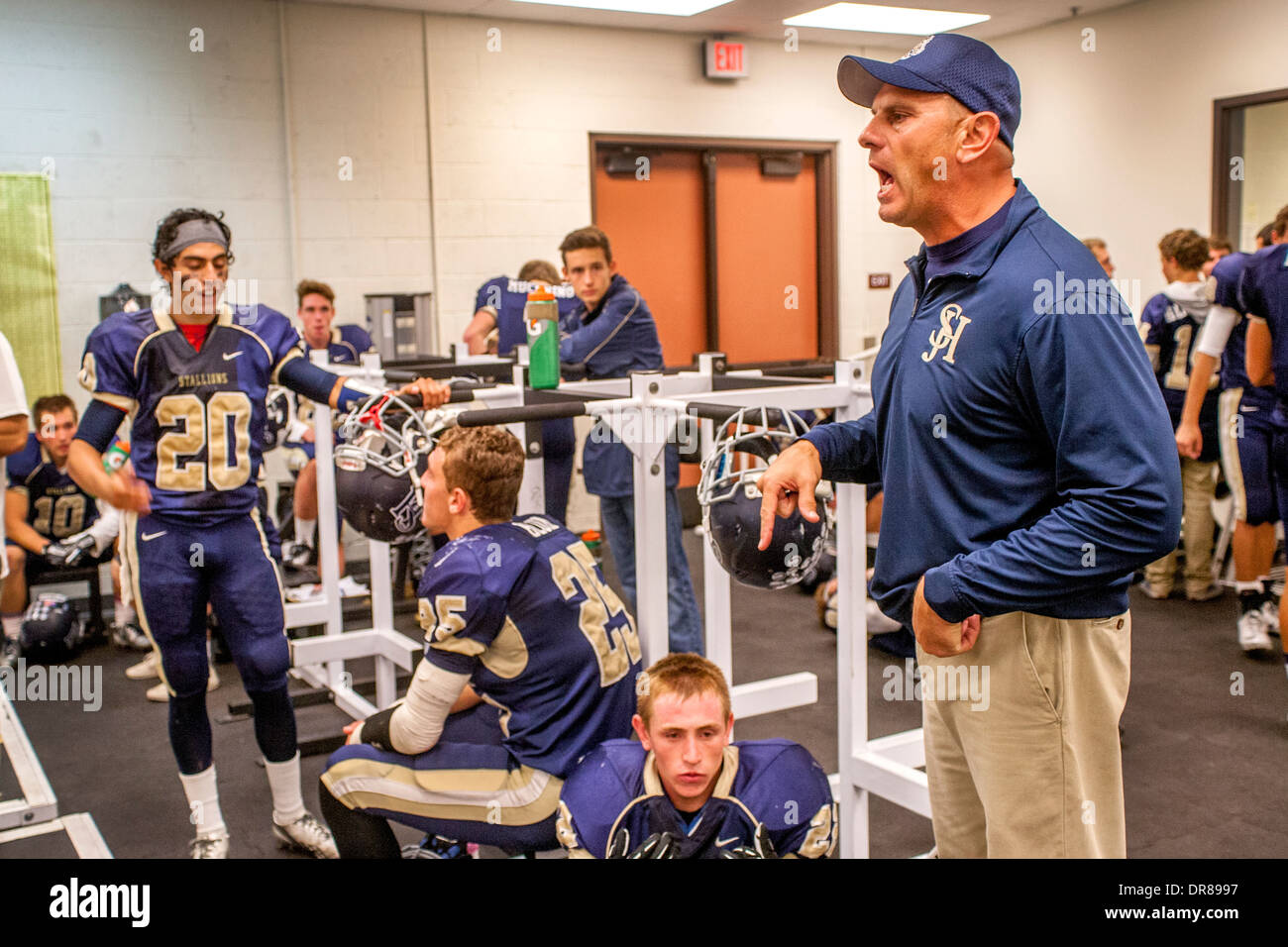 Ein Highschool-Football-Trainer begeistert seine Spieler in der Umkleidekabine in der Halbzeit eines Spiels Nacht in San Juan Capistrano, Kalifornien Stockfoto