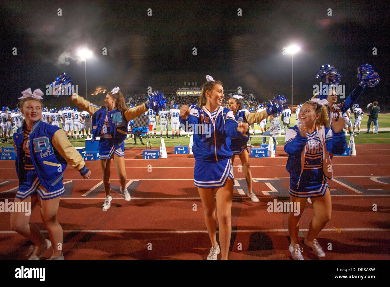Cheerleader unterhalten die Zuschauer bei einem Fußballspiel Gymnasium Nacht in San Juan Capistrano, Kalifornien. Stockfoto