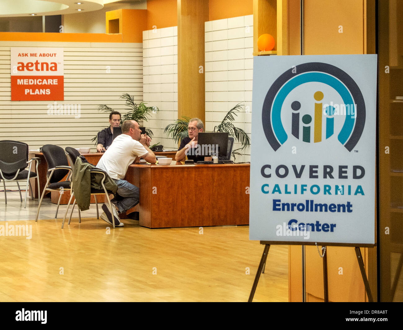 Versicherungsagenten beraten Affordable Car Act oder Obamacare, nannte bedeckt California im Zustand bei einem Laguna Hills, CA, Shopping-Mall Shop. Beachten Sie die Schilder am Eingang. Stockfoto